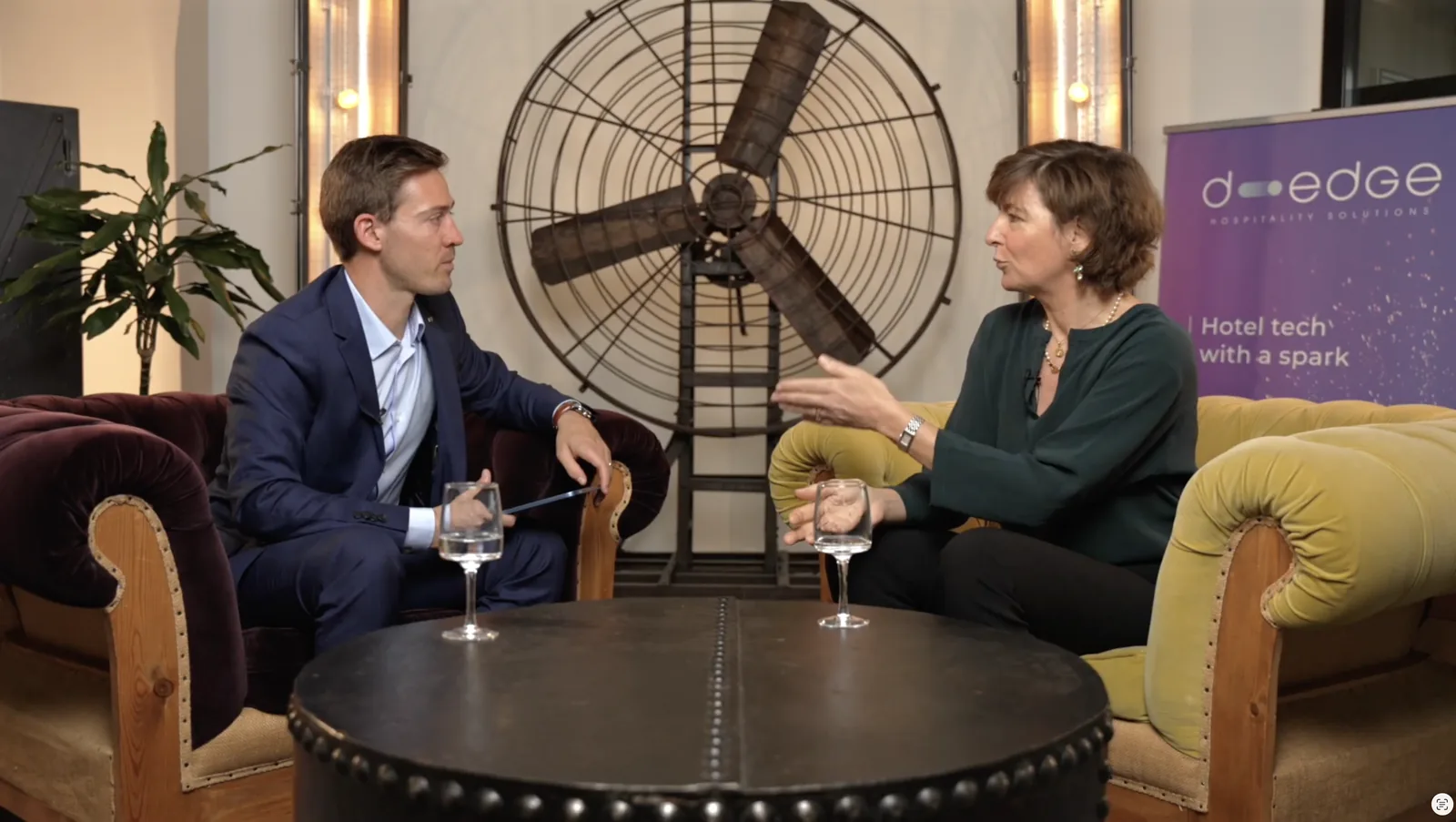 Plateau d'interview D-EDGE : échange en fauteuils devant un ventilateur industriel, sur la distribution hôtelière
