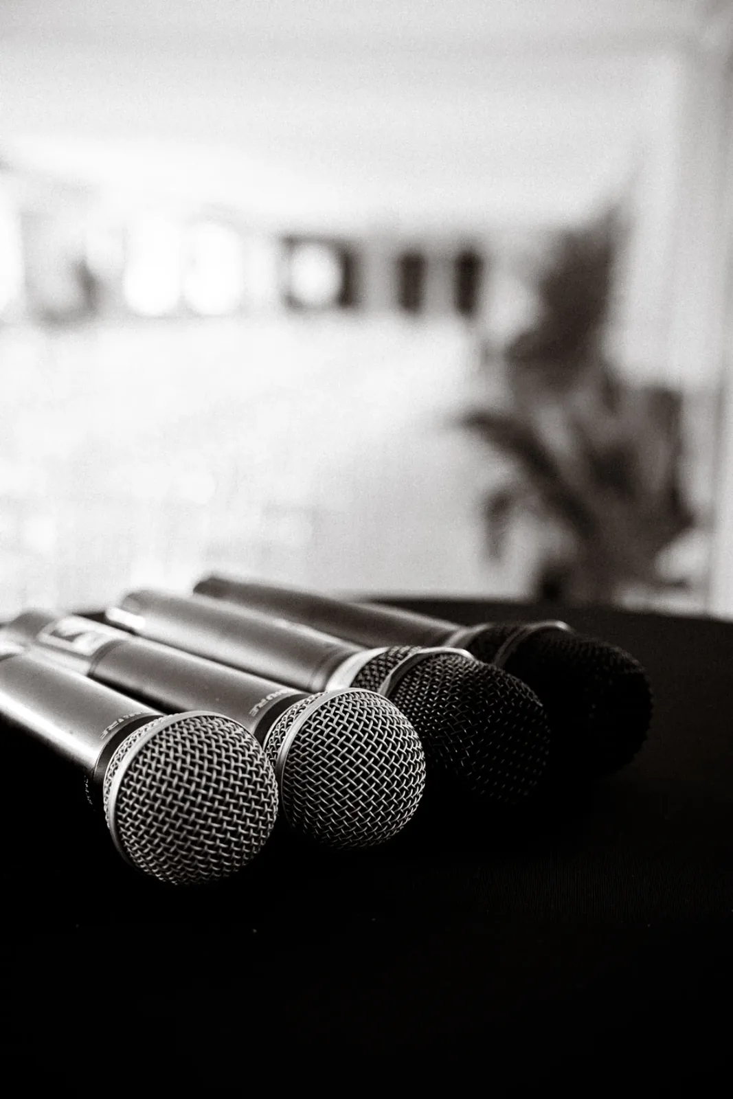 Micros alignés avant une conférence, photographiés en noir et blanc