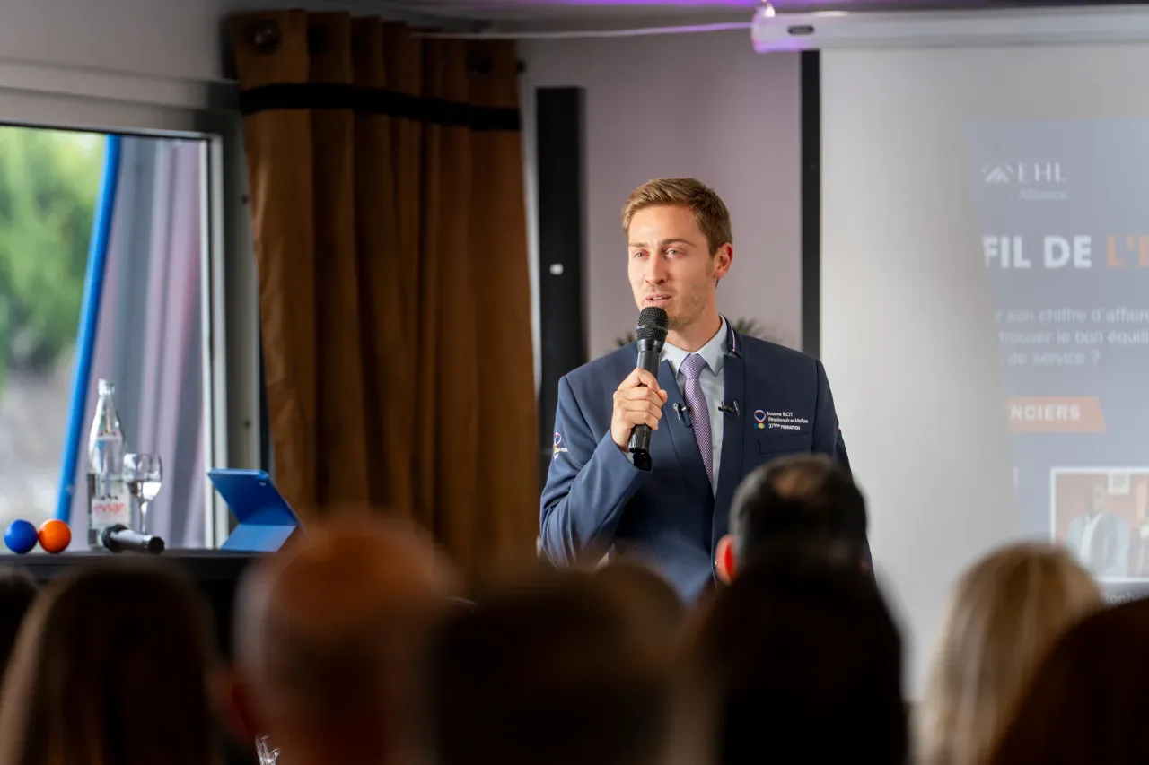 Orateur au micro devant son écran de présentation lors d'une conférence HotelPartner