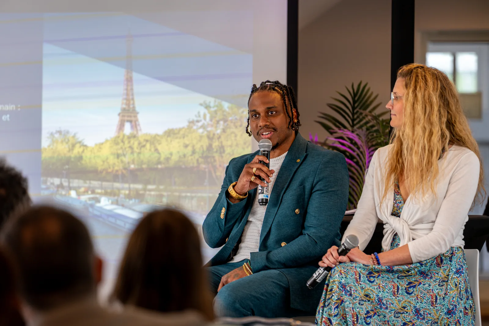 Intervenant au micro lors d’une table ronde à Paris, la Tour Eiffel en arrière-plan