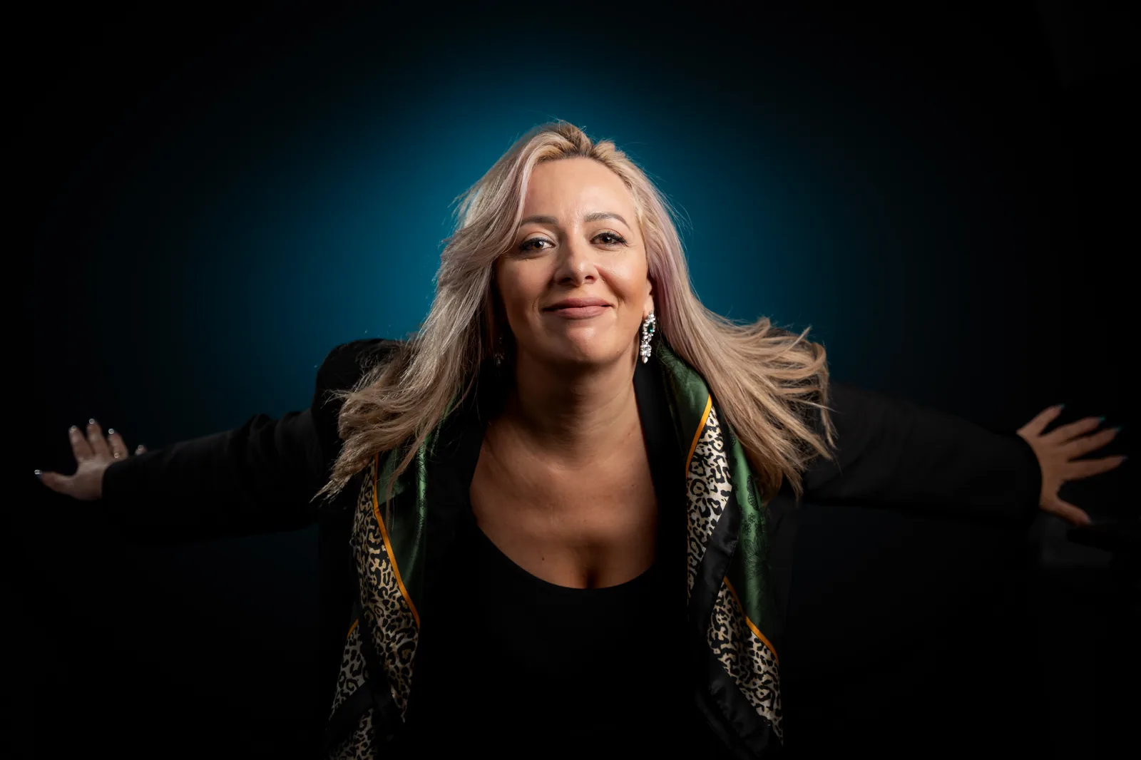 Portrait professionnel en studio d’une femme souriante, bras ouverts