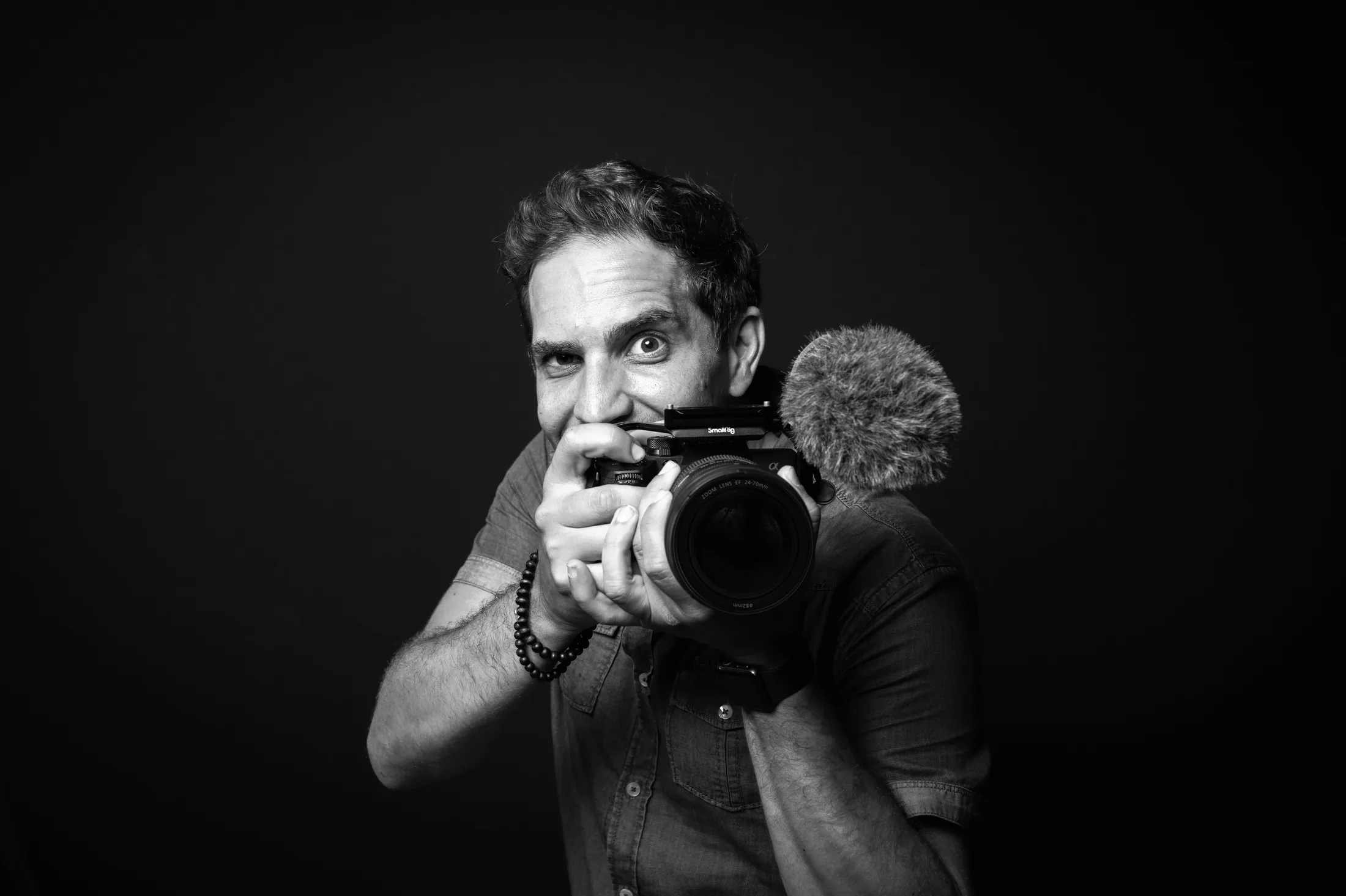 Robin Sforza, photographe à Grenoble, appareil photo en main : portrait noir et blanc
